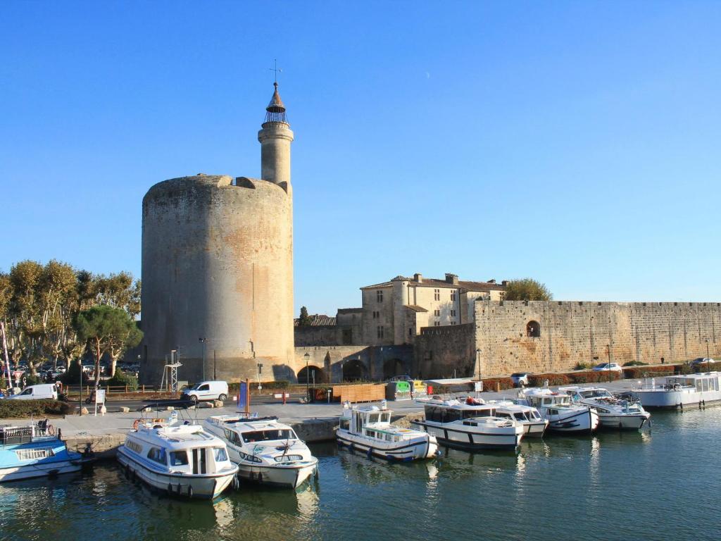 a group of boats in the water near a castle at Holiday Home La Maison Theaulon by Interhome in Aigues-Mortes