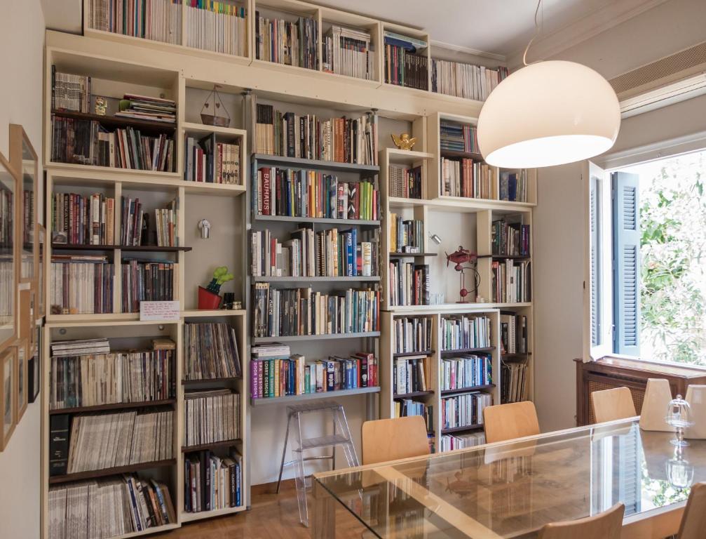 een muur van boekenplanken gevuld met boeken bij 90m2 lovely 1-bedroom apartment in Paleo Faliro in Athene