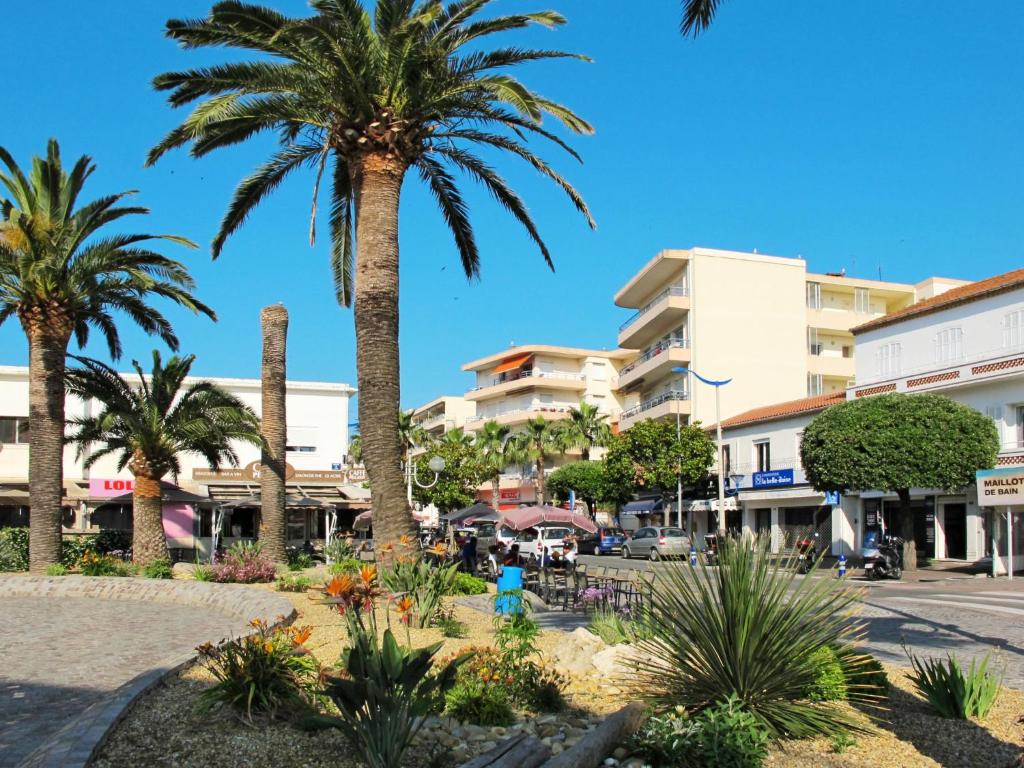 a city street with palm trees and buildings at Apartment Les Jardins d&#39;Amaryllis-8 in Cavalaire-sur-Mer