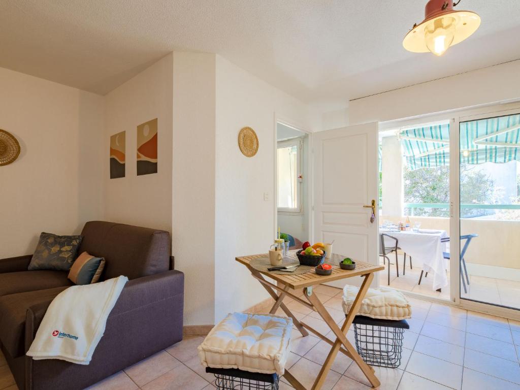 een woonkamer met een bank en een tafel bij Apartment Résidence Villa Toscane by Interhome in Saint-Raphaël