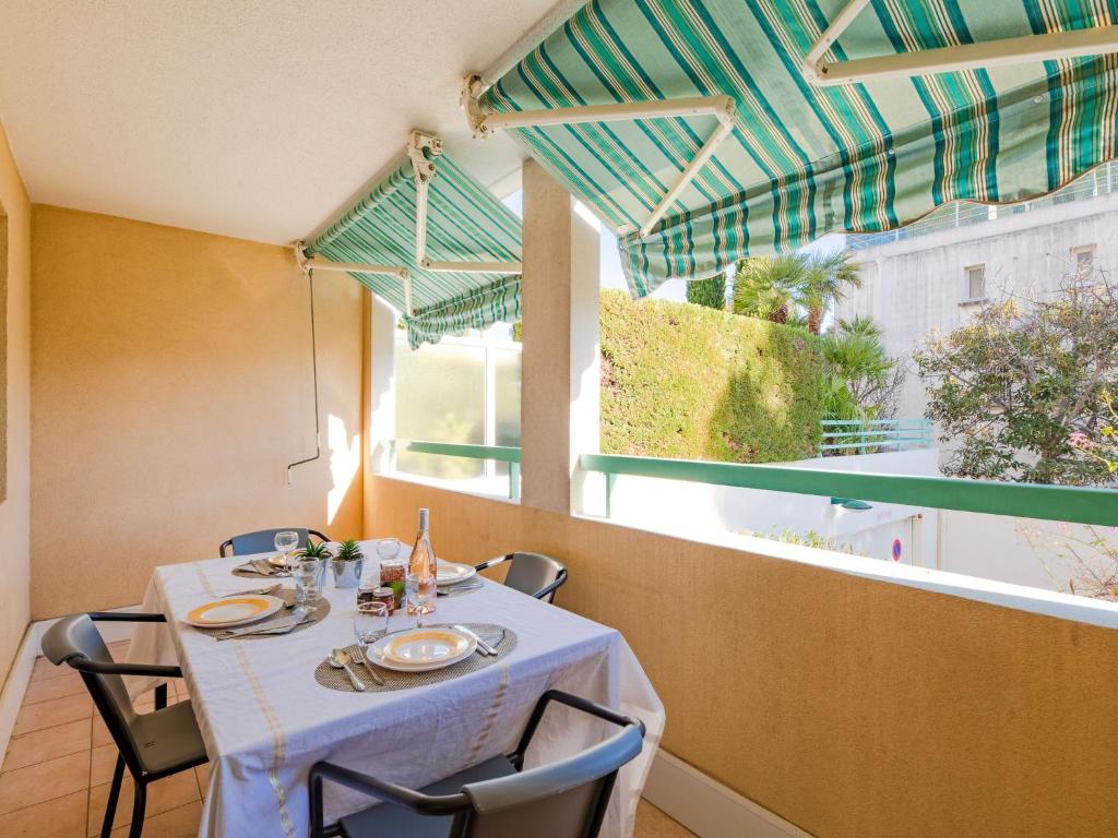 une table avec un chiffon de table blanc devant une fenêtre dans l'établissement Apartment Résidence Villa Toscane by Interhome, à Saint-Raphaël