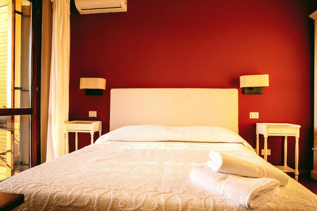 ein Schlafzimmer mit einem Bett mit einer roten Wand in der Unterkunft Guest House DaLù in Dorgali