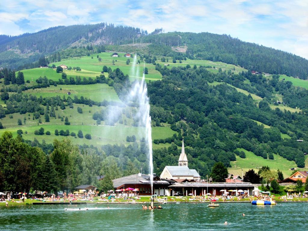 a fountain in the middle of a lake in front of a mountain at Apartment Appartment Wiesberg by Interhome in Niedernsill