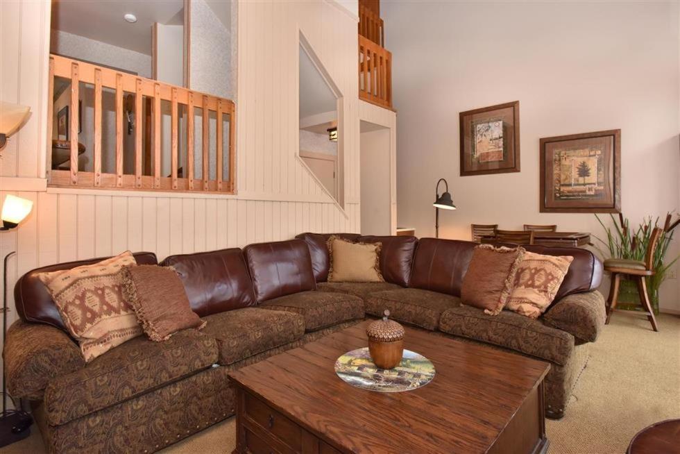 a living room with a brown couch and a table at Seven Springs 3 Bedroom Standard Townhouse, Sleeps 11! condo in Champion