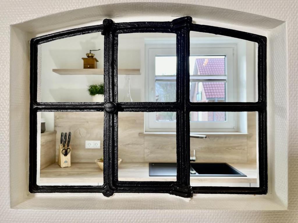 a window with a black frame in a kitchen at Lönnegarden - Tante Emma in Kellenhusen