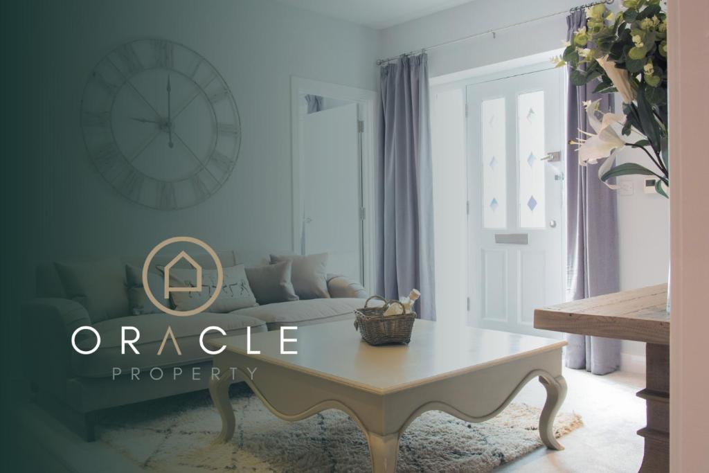 a living room with a table and a clock on the wall at Modern Apartment with FREE Parking, WIFI and Netflix in Stratford-upon-Avon