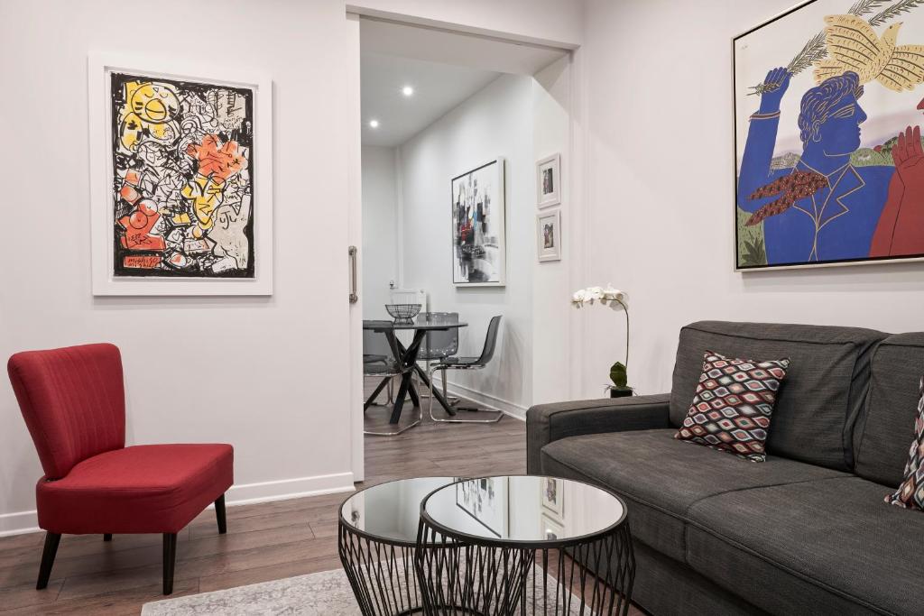 a living room with a couch and a red chair at Valaoritou Boutique Apartment,Kolonaki in Athens