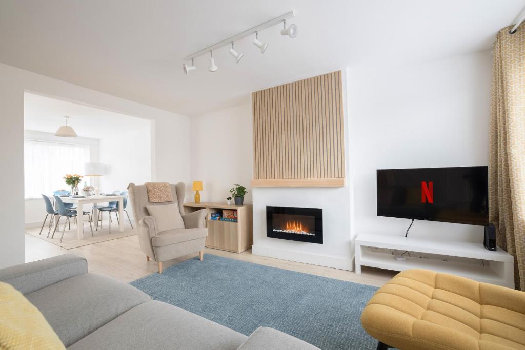 a living room with a couch and a fireplace at Elegant home mod kitchen, fast Wi-Fi, free parking in Carrickfergus
