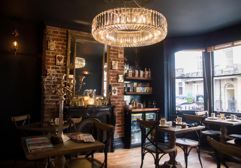 un restaurante con mesas y sillas y una lámpara de araña en The Twenty One, en Brighton & Hove