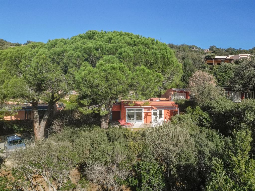 uma casa no meio de uma floresta de árvores em Holiday Home Villa Marzia Mare & Golf by Interhome em Punta Ala