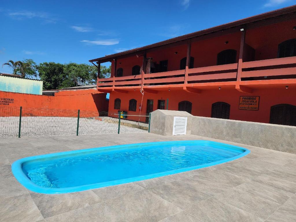 une grande piscine bleue en face d'un bâtiment dans l'établissement 0001.08 - Maranduba - Apto - 2 Dormitório - 8 Pessoas - 2 Quadras Do Mar - Piscina - Wi-Fi (Excursão 96 Pessoas), à Ubatuba