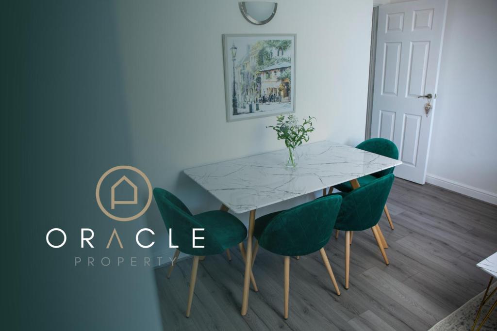 a dining room with a table and green chairs at Modern Townhouse Apartment with FREE Parking, Wifi & Netflix in Stratford-upon-Avon