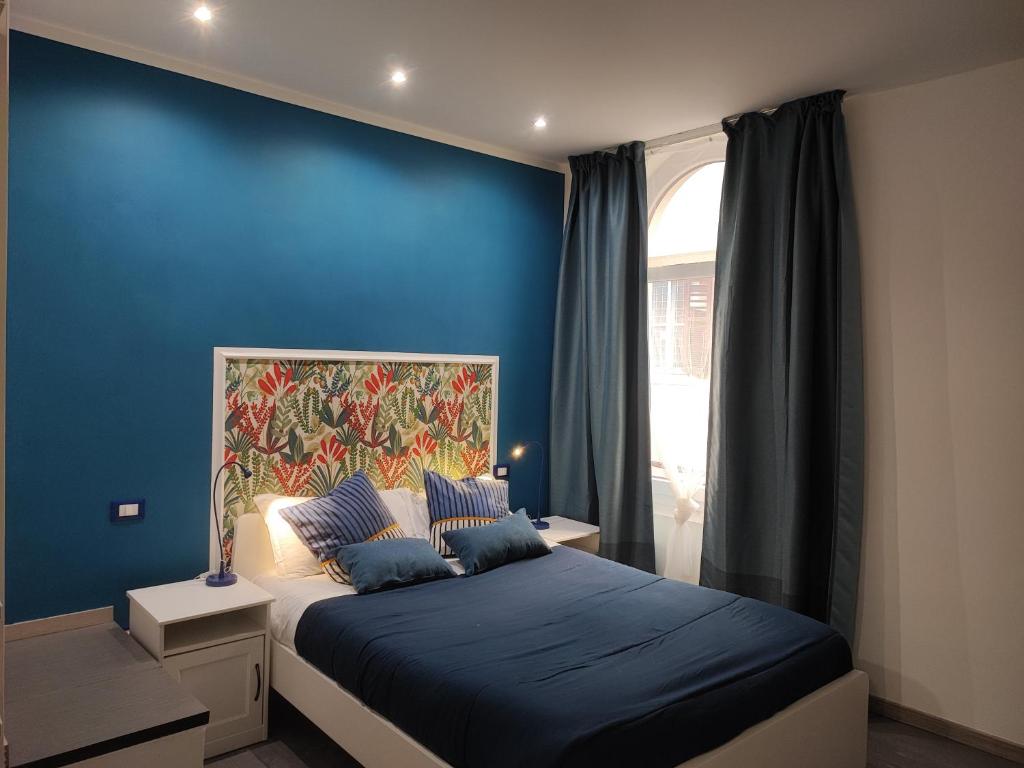 1 dormitorio con paredes azules y 1 cama con sábanas azules en Capitolina Guest House, en Roma