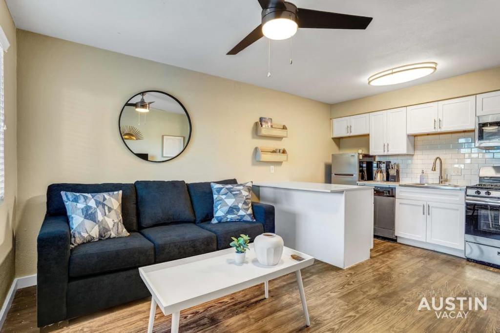a living room with a couch and a table at Get Comfy Memory Foam Beds and Tub in Central ATX in Austin