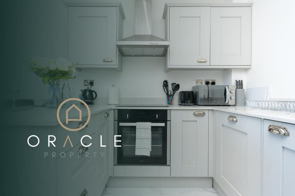 uma cozinha branca com armários e electrodomésticos brancos em Modern Apartments in Kings Lynn with Free Wi-Fi em King's Lynn