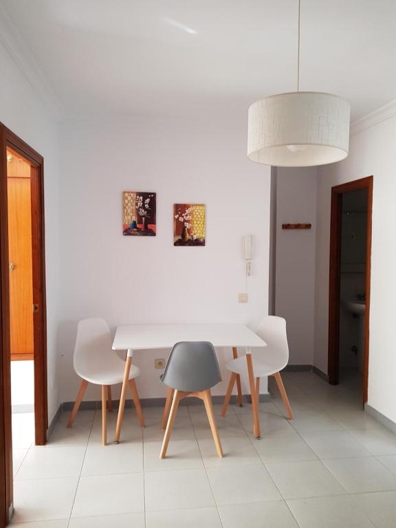 ein weißes Esszimmer mit einem weißen Tisch und Stühlen in der Unterkunft Apartamento Antonio Machado in Barbate