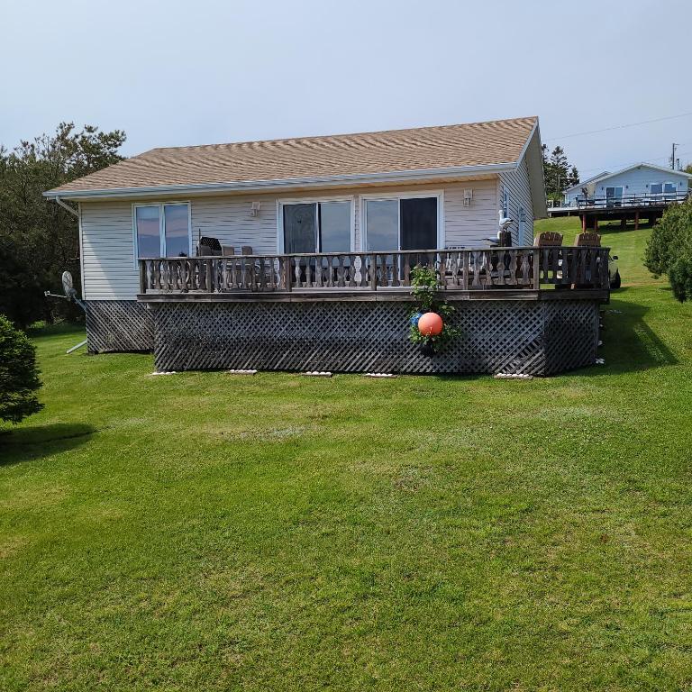 una casa con una gran terraza con una bola de naranja. en Sleepy Pines Oceanfront Cottages, en Cumberland