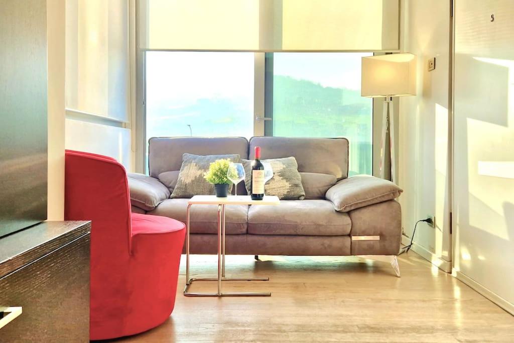 a living room with a couch and a red chair at [LOFT Romantico] Vista Panoramica vicino al Mare in Lido di Fermo