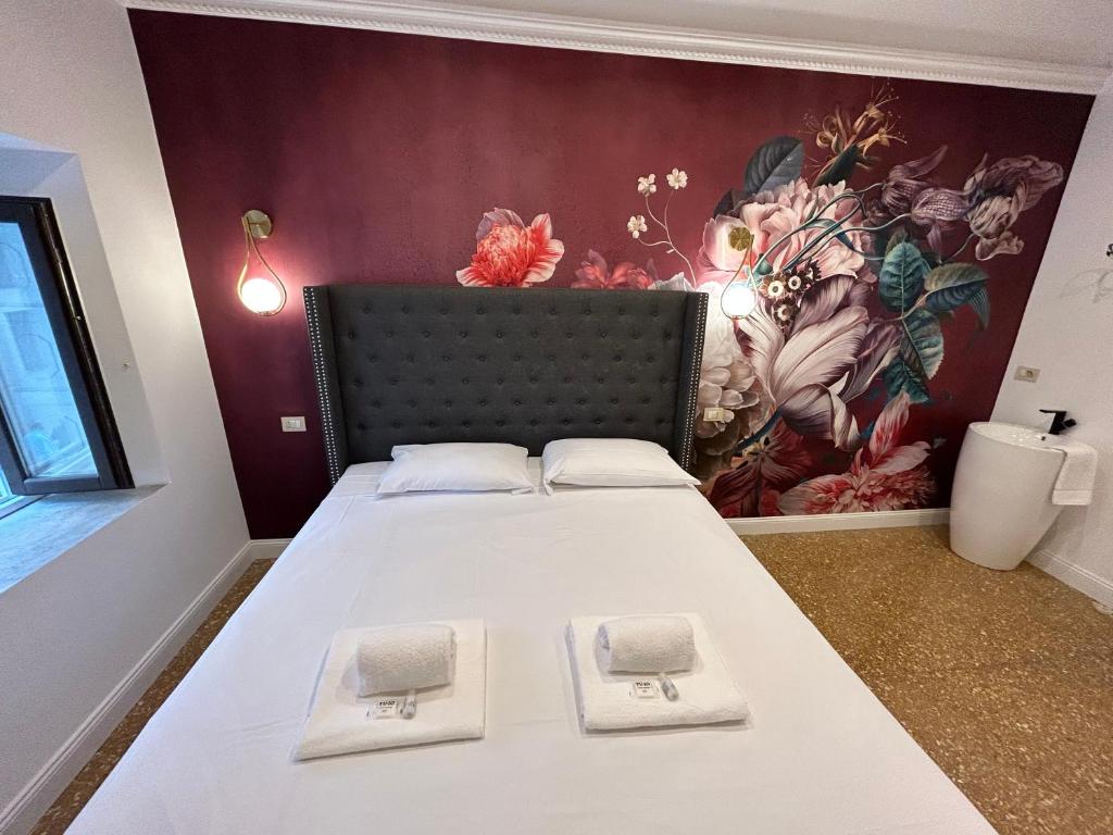 um quarto com uma cama com um quadro na parede em Raffaello's Place em Roma