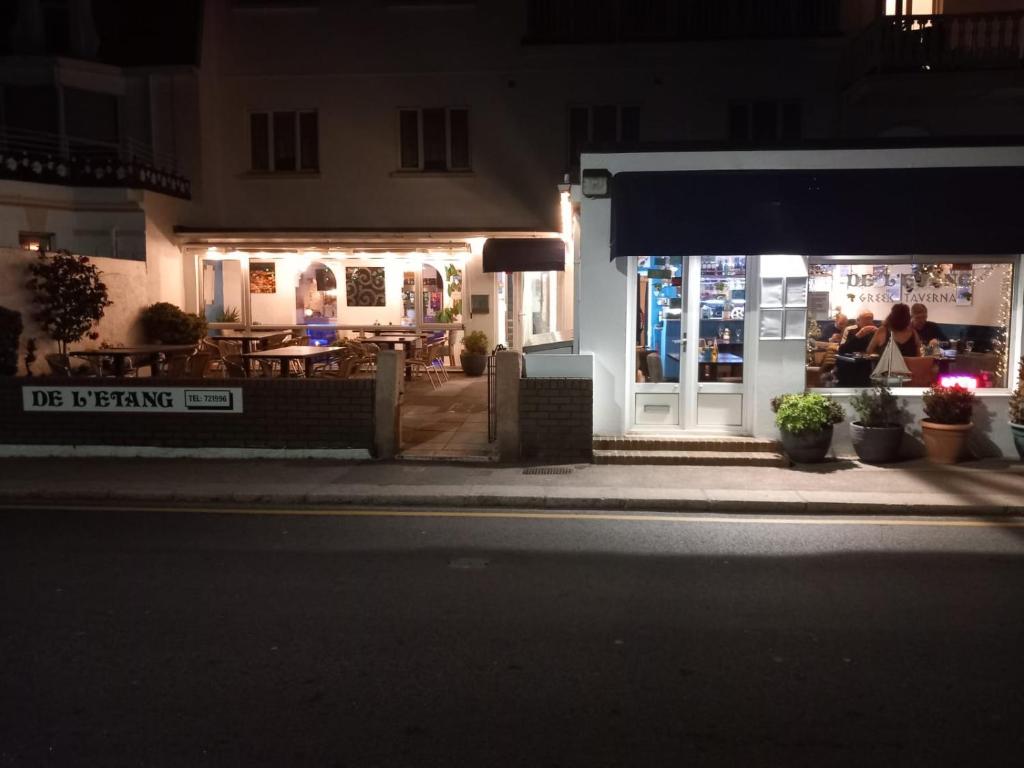 a restaurant with people sitting outside at night at De L'Etang in Saint Helier Jersey