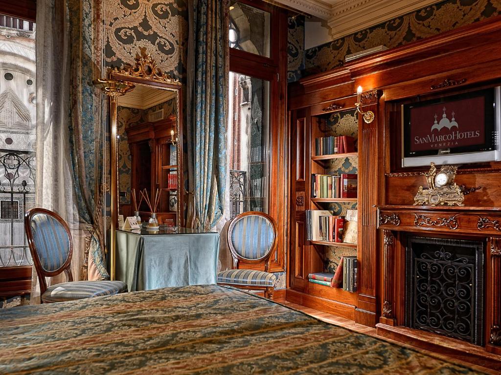 sypialnia z łóżkiem, kominkiem i telewizorem w obiekcie Bellevue Luxury Rooms - San Marco Luxury w Wenecji