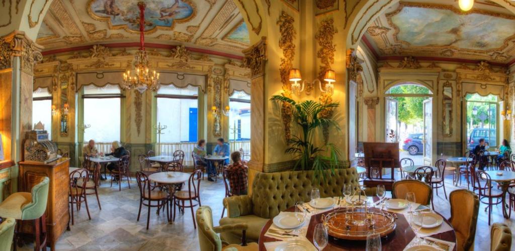 restauracja ze stołami i krzesłami w pokoju w obiekcie La Linda Little Apartments w Kadyksie