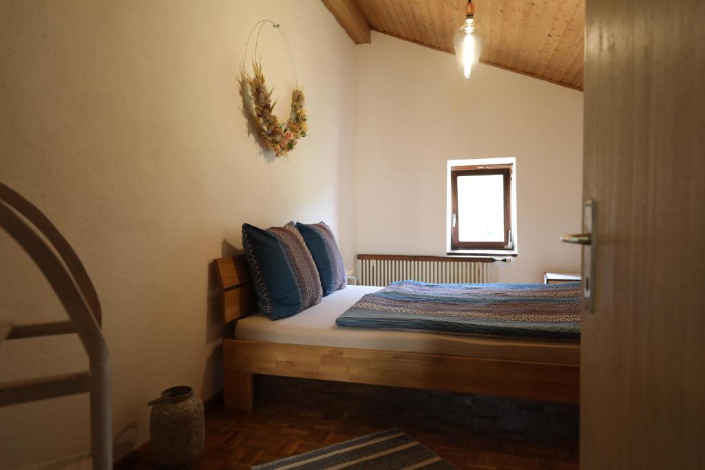 una camera da letto con un letto con cuscini blu e una finestra di Casa Holamundo - romantisches Tessiner Steinhaus (vegi) a Lugano