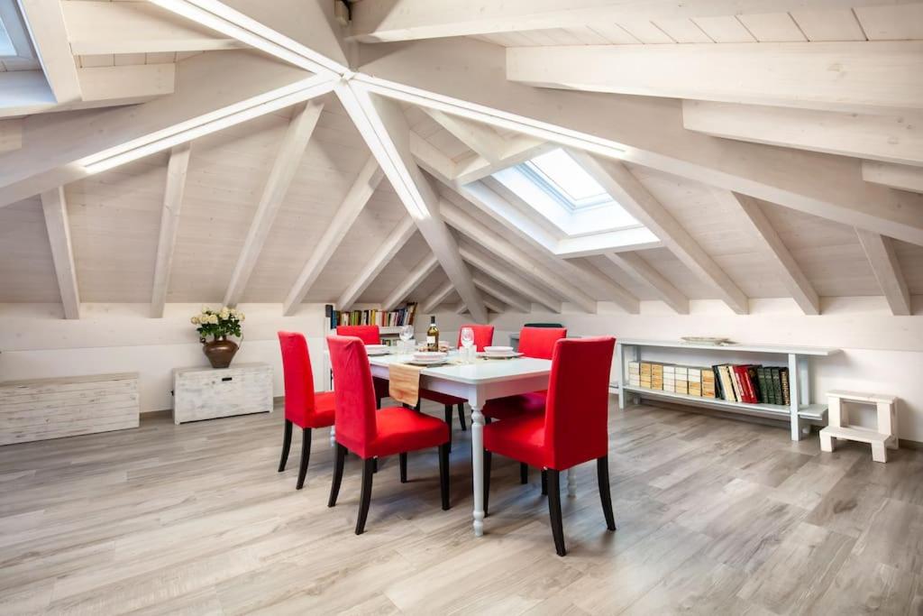 una sala da pranzo con tavolo e sedie rosse di [500 mt. DAL MARE] WiFi Clima & Design a Porto San Giorgio