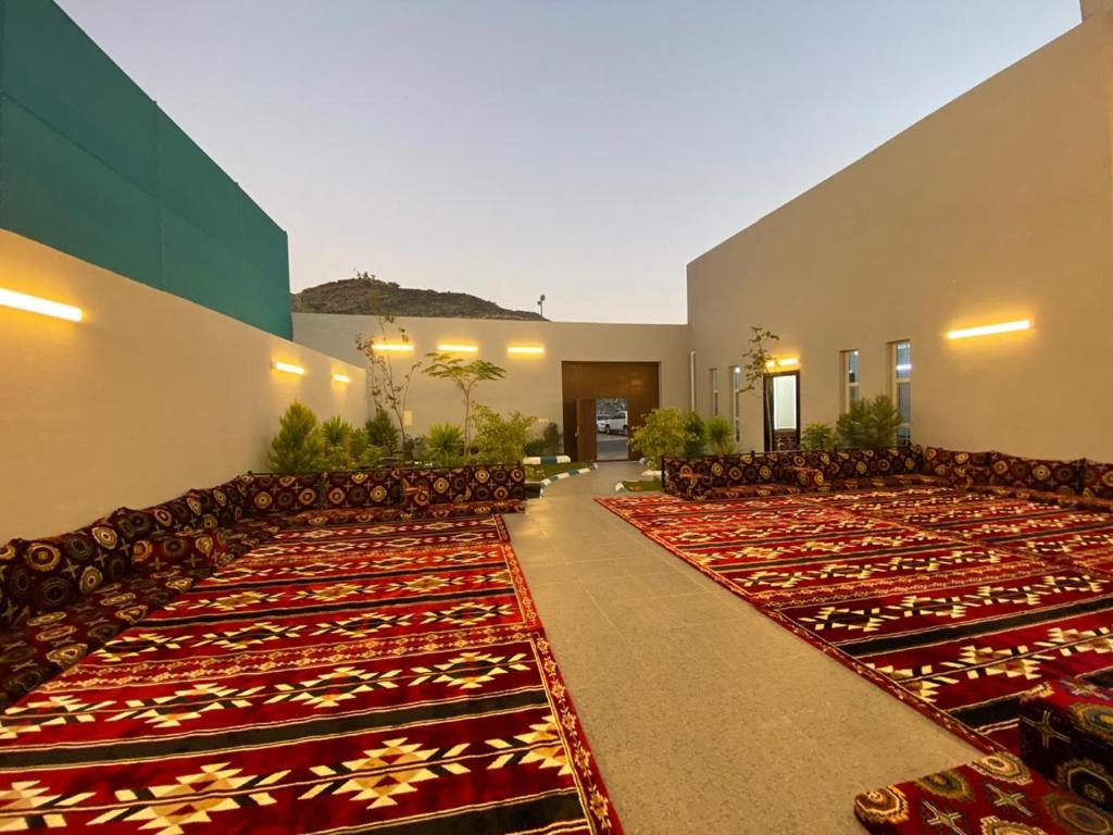 une grande chambre avec des chaises et des tapis dans un bâtiment dans l'établissement شاليهات غزال للفلل الفندقية الفاخرة, à Taif