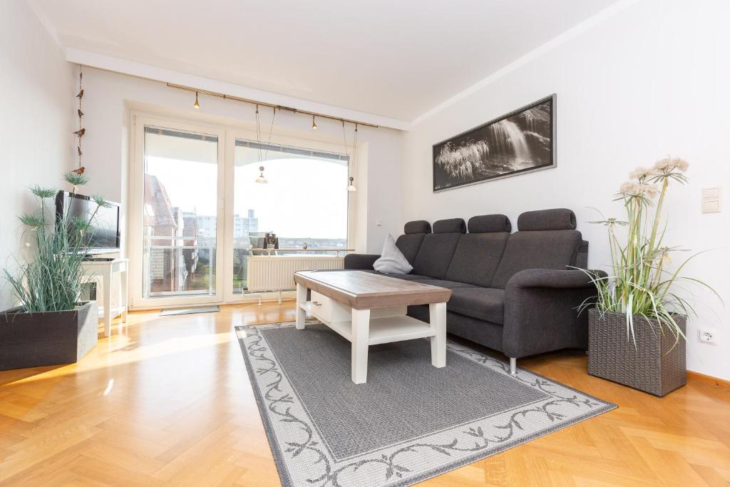 ein Wohnzimmer mit einer Couch und einem Tisch in der Unterkunft Strandnixe 301 in Döse
