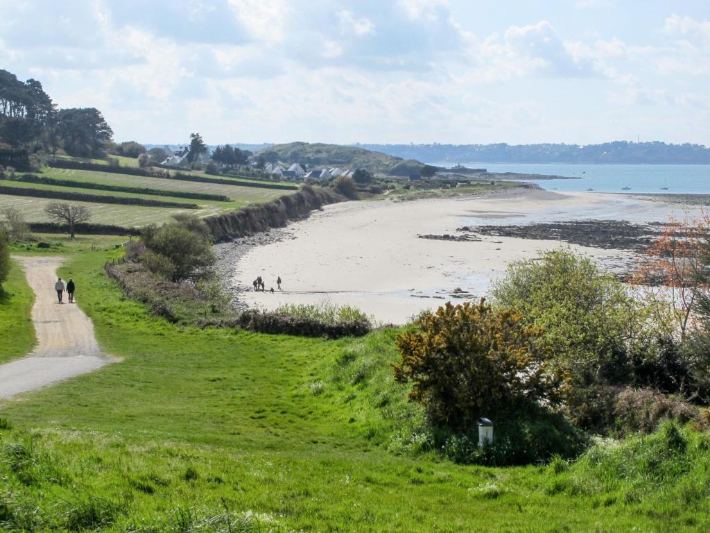 a view of a beach with people walking on a path at Holiday Home Les Hortensias - KSD101 by Interhome in Kermaria-Sulard
