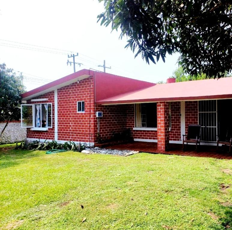 uma casa de tijolos vermelhos com um telhado vermelho em Bonita casa vacacional en Veracruz em Costa Esmeralda