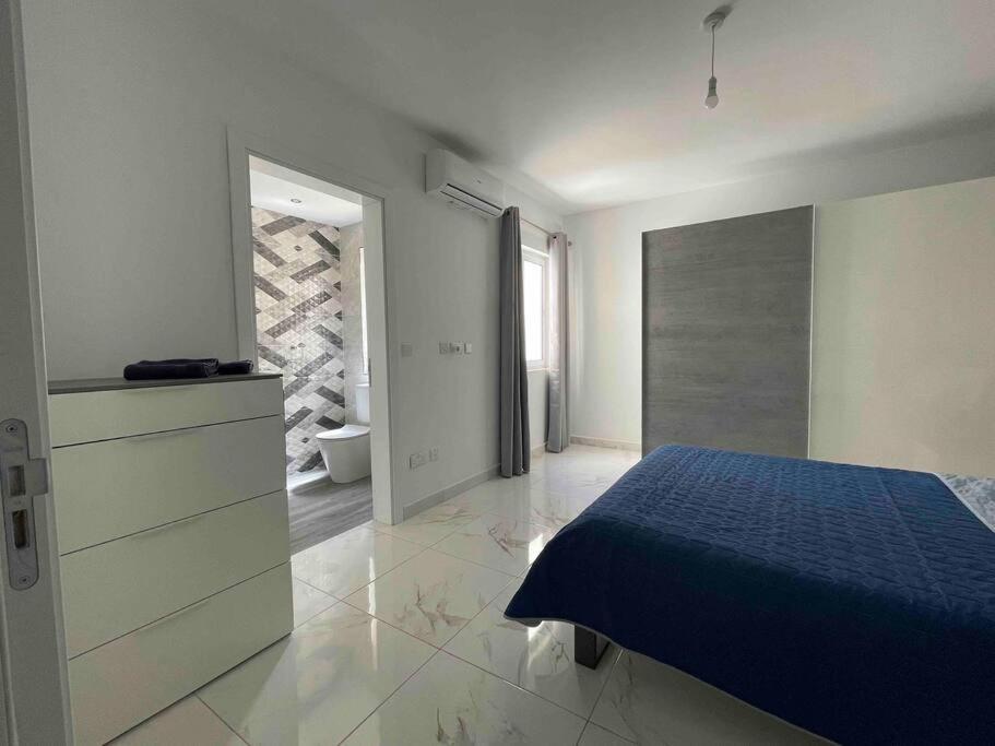 um quarto com uma cama azul e uma casa de banho em 2 bedroom Apartment in Mellieha with Sea Views and Close to all Amenities em Mellieħa