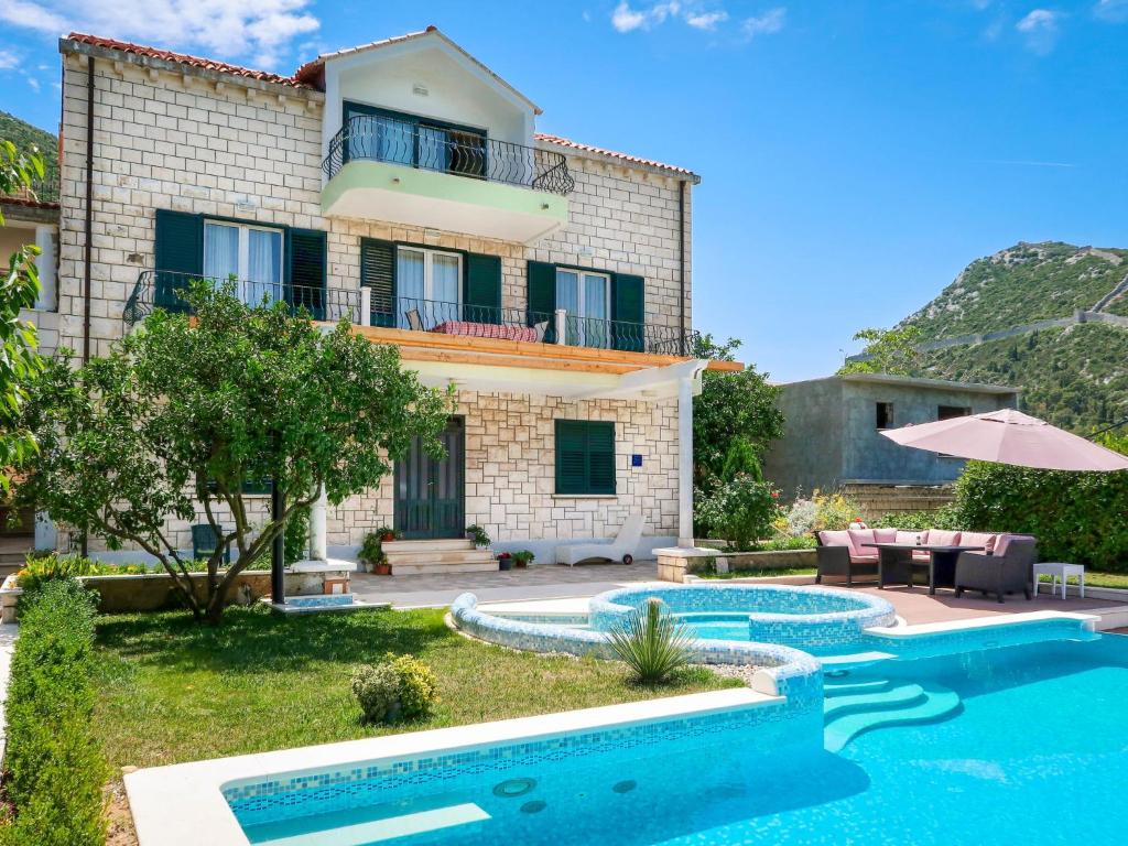 een villa met een zwembad en een huis bij Apartment Siga by Interhome in Ston