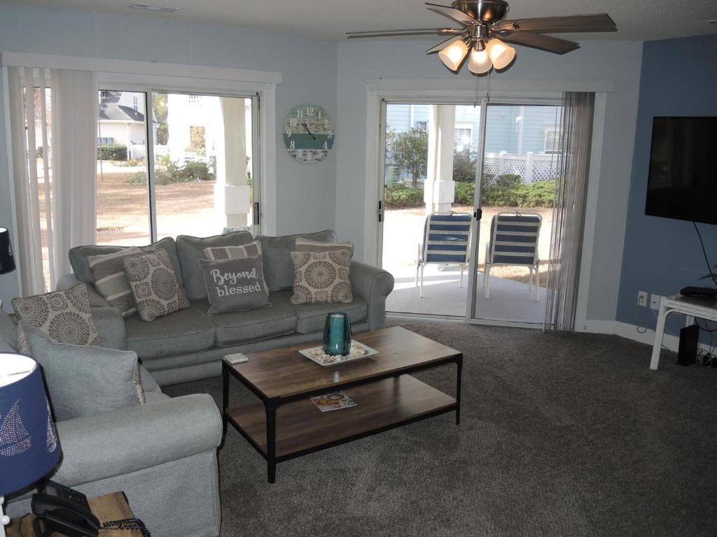 a living room with a couch and a coffee table at Brunswick Plantation Villa 1203 with Full Kitchen, Golf Course Onsite, and Short Drive to the Beach villa in Calabash