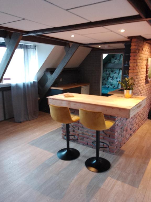 a wooden table and two yellow chairs in a room at Vakantieverhuur Noordwolde in Noordwolde