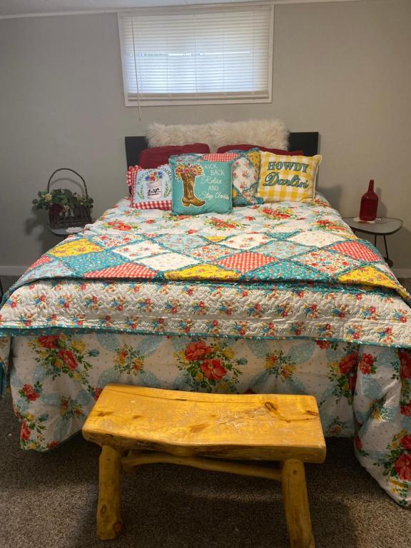 een slaapkamer met een bed met een quilt en een houten bank bij The Cottages on Carbon Avenue in Price