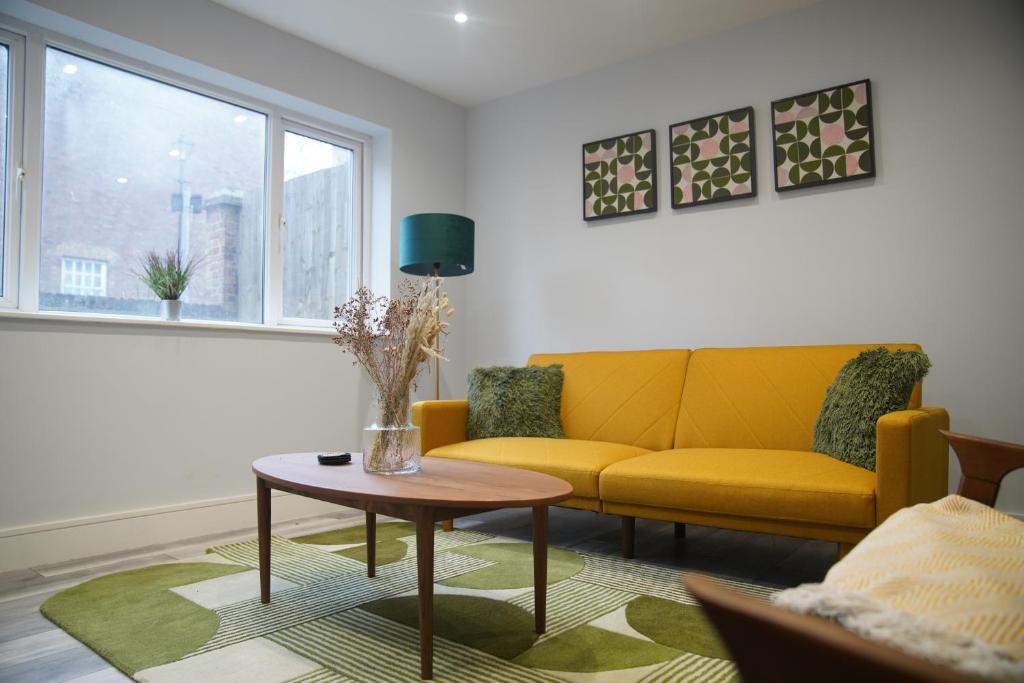 a living room with a yellow couch and a table at Lux 3BDR for 7 nr London Eye in London