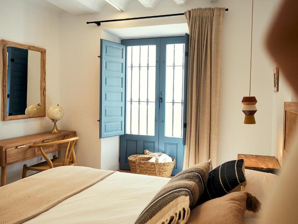 a bedroom with a bed and a window and a desk at LIGNUM Casa Rural in Ayna