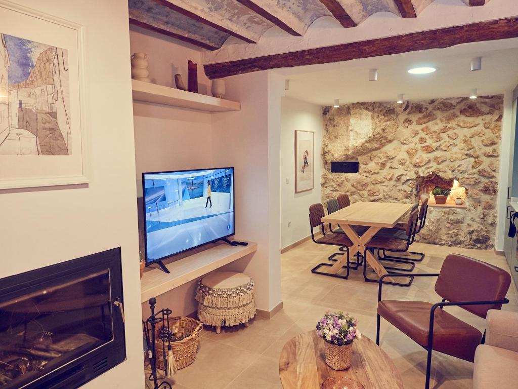 a living room with a television and a table at LIGNUM Casa Rural in Ayna
