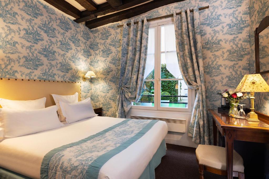 Giường trong phòng chung tại Relais Hôtel du Vieux Paris