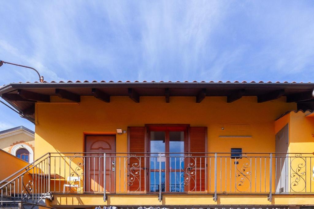 una casa gialla con un balcone di fronte di Affittacamere Grugliasco Ressia a Grugliasco