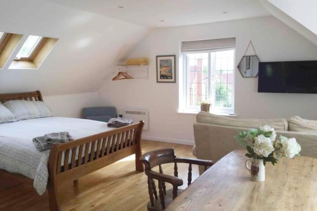 a bedroom with a bed and a couch and a table at Oak Loft in Lyme Regis
