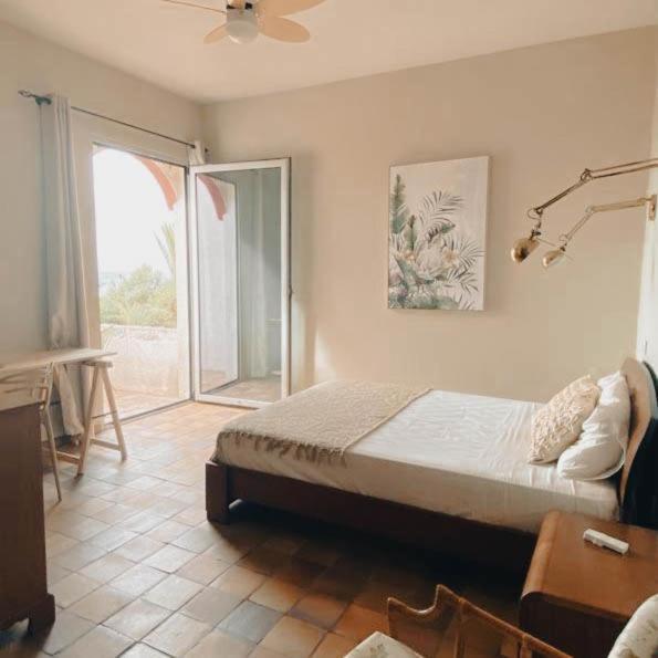 a bedroom with a bed and a sliding glass door at Porto Santo Destination in Porto Santo