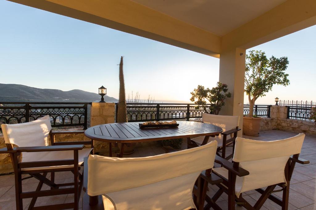 Falasarna's Sunset Home في فالاسارنا: طاولة وكراسي على شرفة مطلة على المحيط