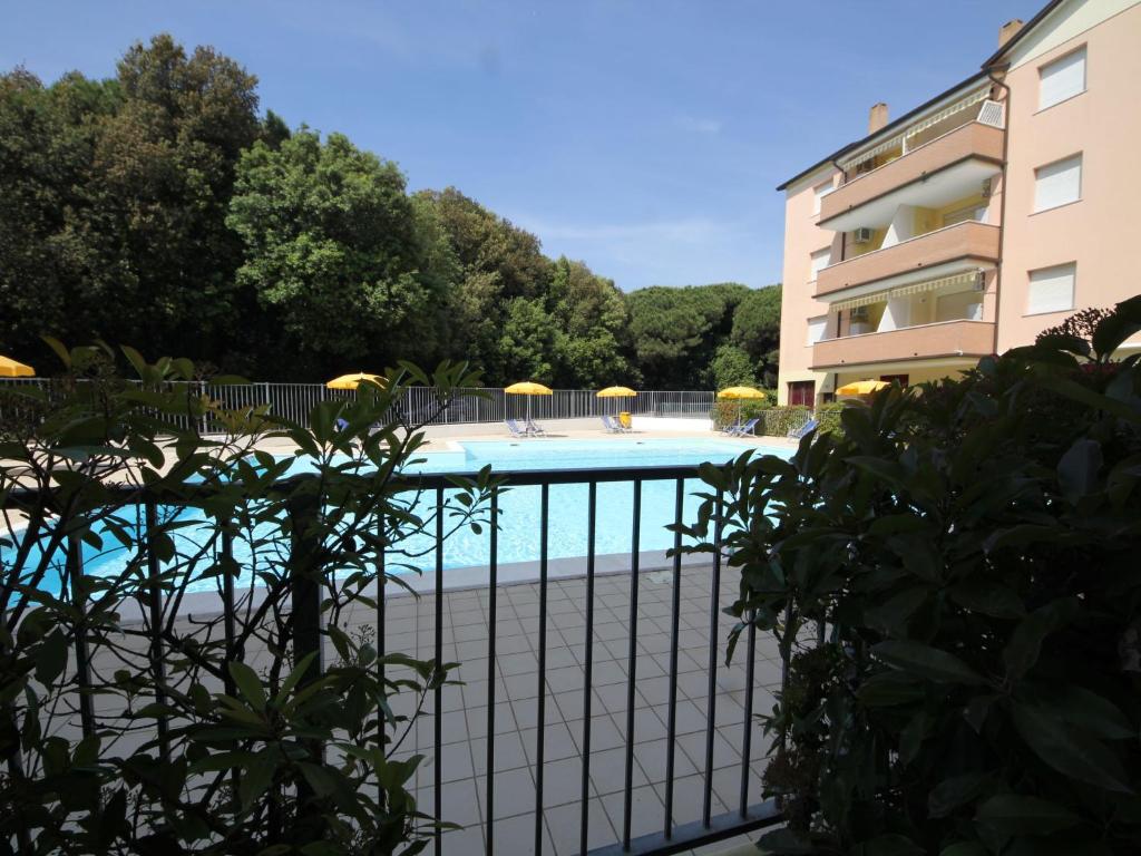 a swimming pool behind a fence next to a building at Apartment Acquamarina-4 by Interhome in Rosapineta