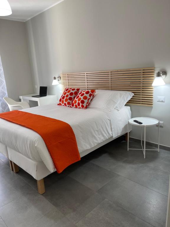 カリアリにあるViaRiva Roomsのベッドルーム1室(大型ベッド1台、赤とオレンジの枕付)