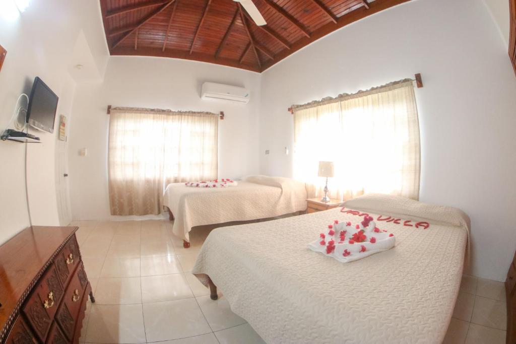um quarto com duas camas com corações vermelhos em Van Villa Guesthouse em Negril