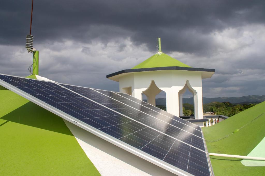 a house with a solar panel and a tower at Van Villa Guesthouse in Negril