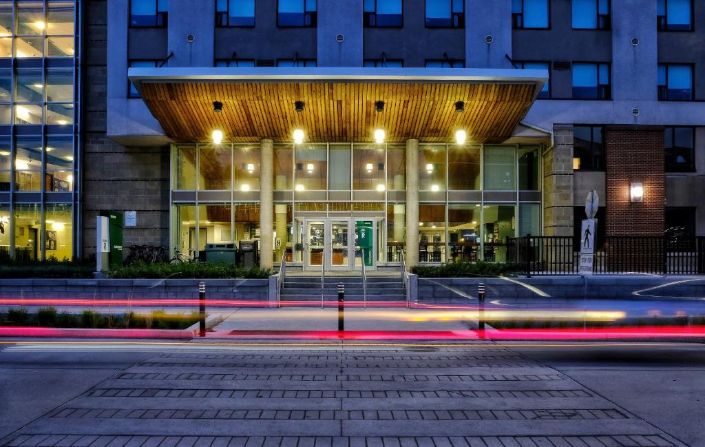 a building at night with cars speeding past it at Residence & Conference Centre - Ottawa West in Ottawa